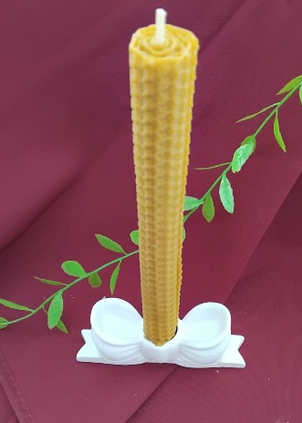 Castiçal em forma de laço com vela de cera de abelha.