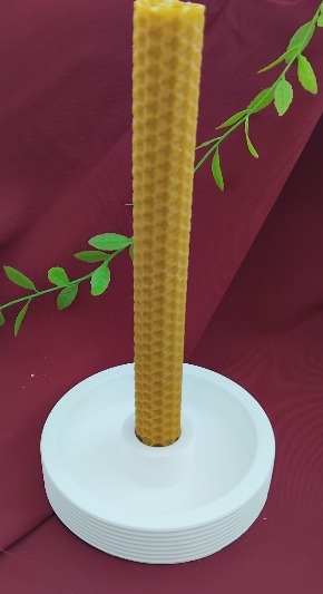 Pequeno castiçal circular com vela de cera de abelha.